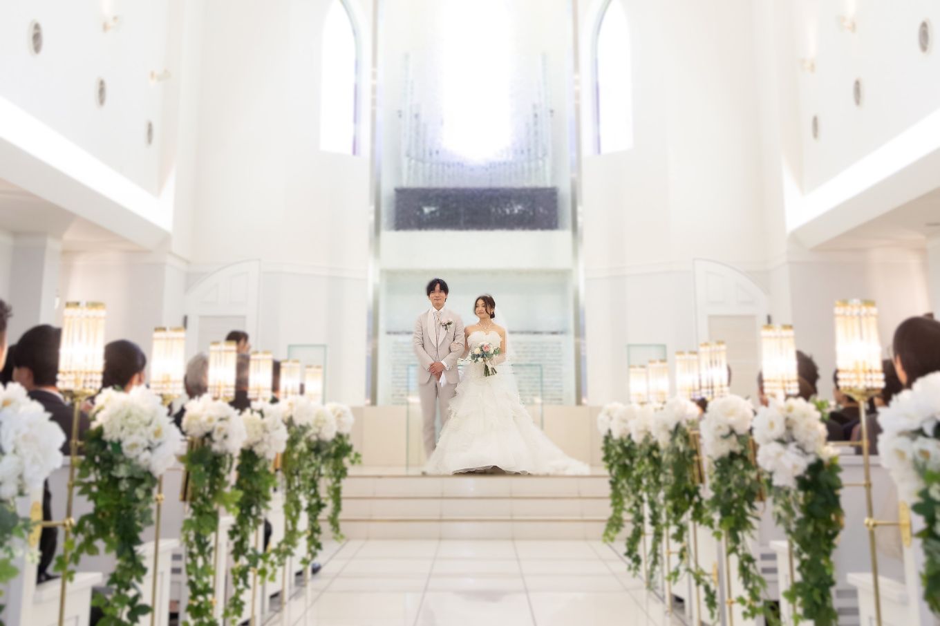 祭壇に立つ新郎新婦とゲストの写真