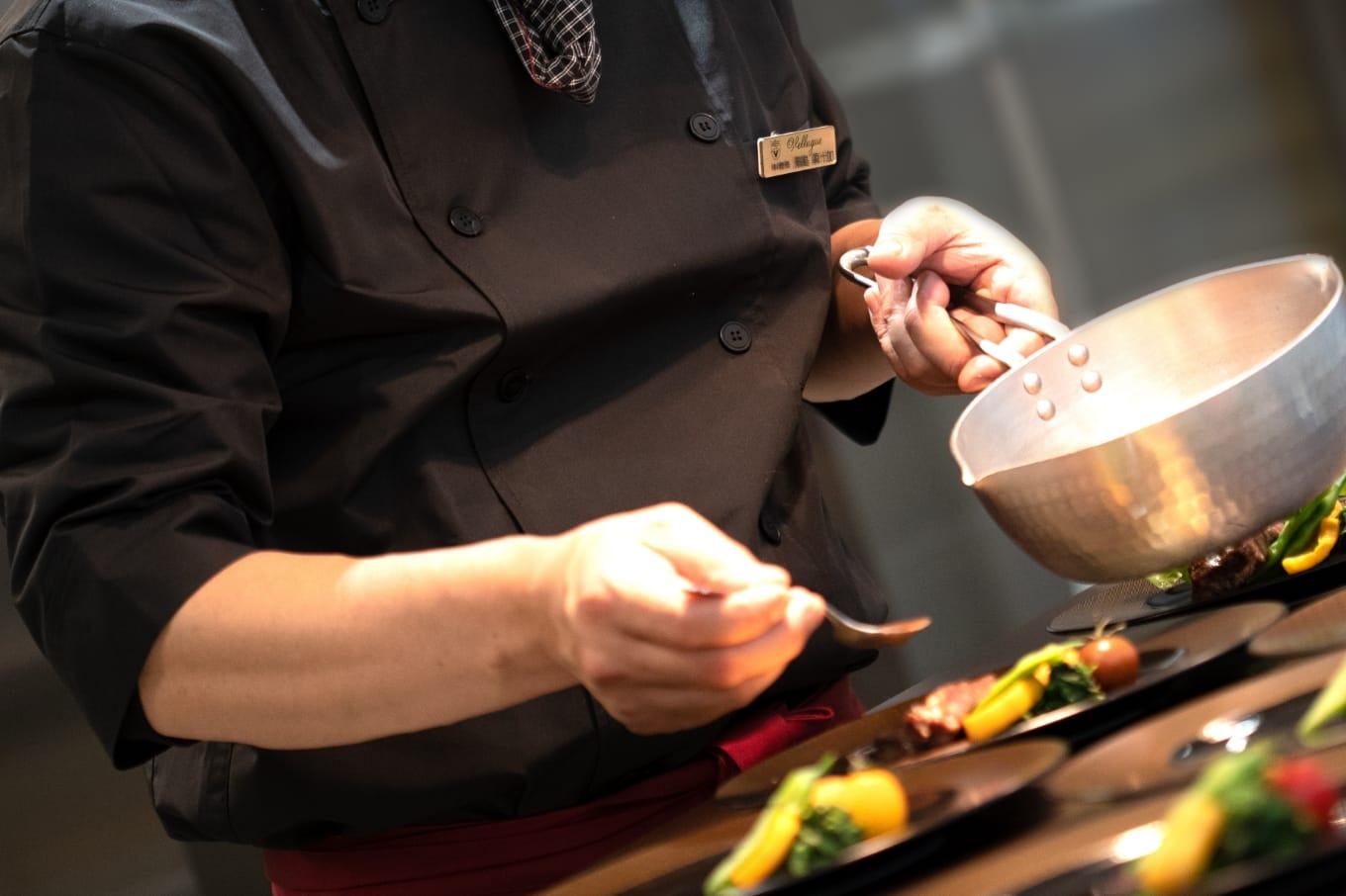 盛り付けされた料理にソースをかける写真