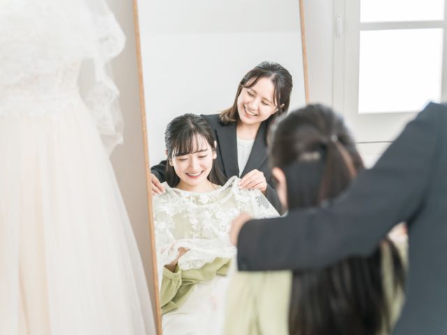 ウェディングドレスを試着する女性の写真