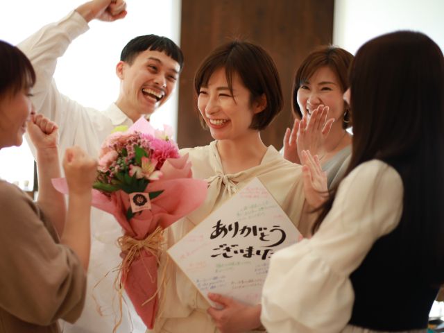 花束と色紙を受け取る女性の写真