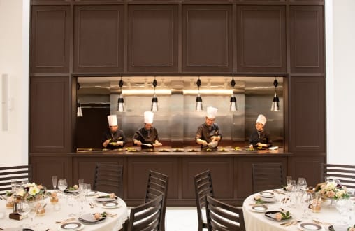 パーティ会場のキッチンで料理をするシェフの写真