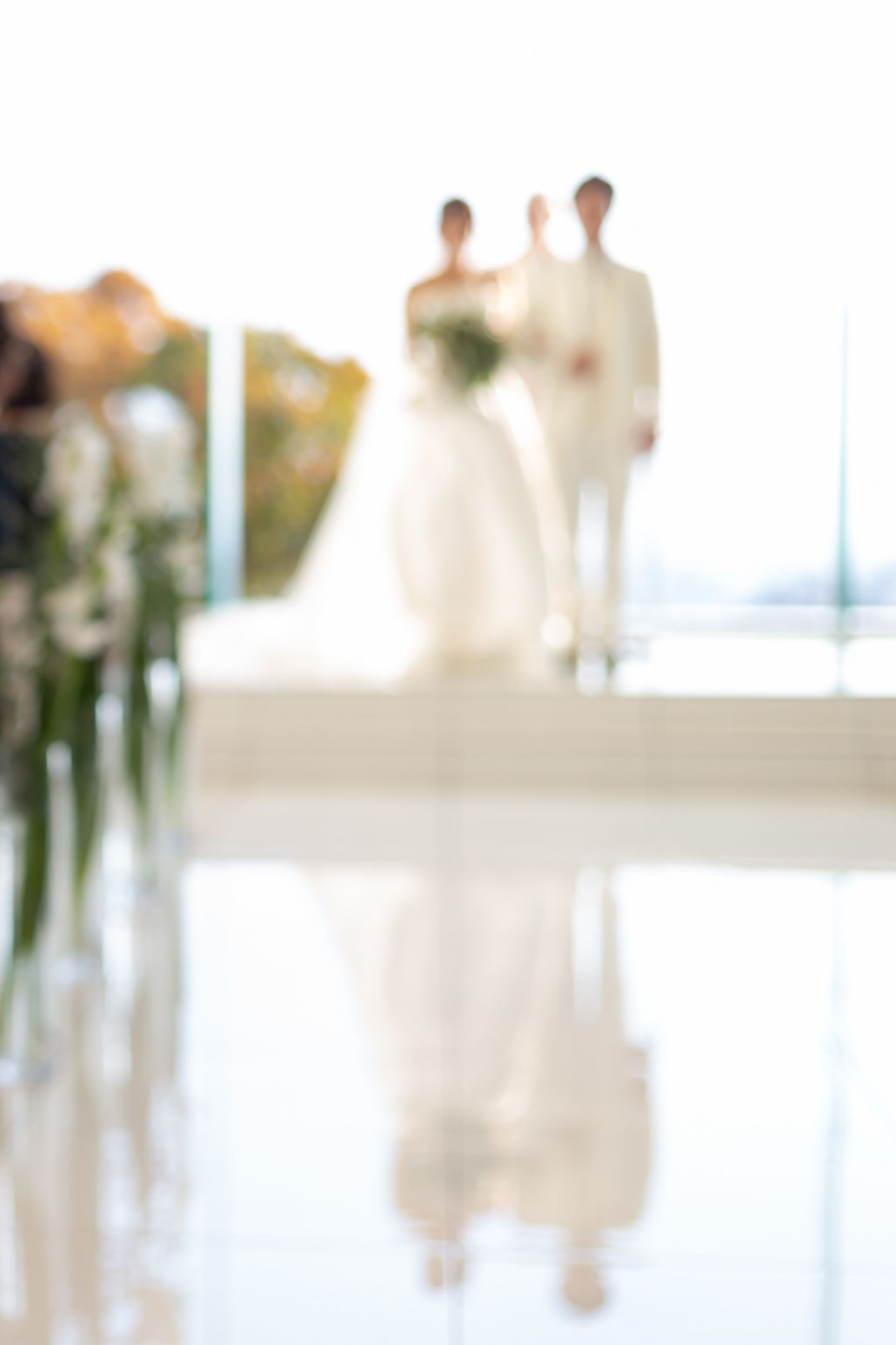 祭壇の上からゲストを見る新郎新婦の写真